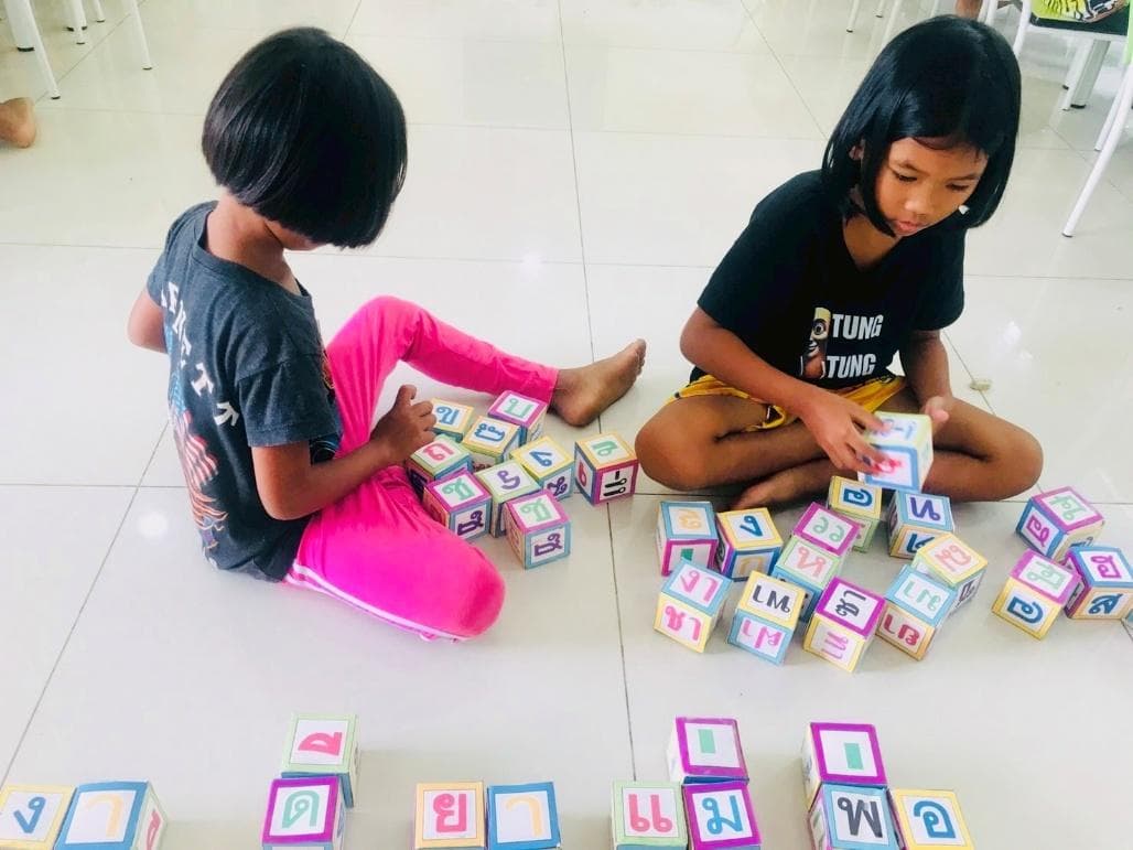 Children learning the Thai alphabet with letter blocks